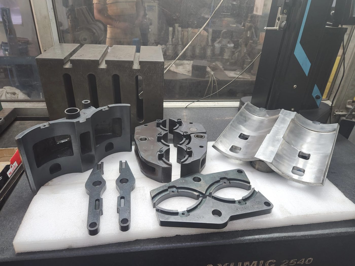 Machined IS-machine parts staged on the bed of a vertical machining centre at the KVG works